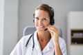 Confident Receptionist Using Headset In Hospital Royalty Free Stock Photo