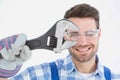 Confident repairman wearing protective glasses while holding wrench Royalty Free Stock Photo