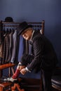 Confident retro style fashion man sitting on wooden stool tailor`s workshop Royalty Free Stock Photo