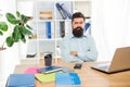 Confident sceptical businessman keeping arms crossed sitting at office desk, confidence