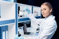 Confident scientist holding flask with reagent and looking at camera in lab Royalty Free Stock Photo