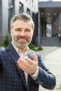 Confident senior businessman extending handshake outside modern office building Royalty Free Stock Photo