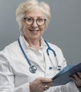 Confident senior female doctor posing and smiling Royalty Free Stock Photo