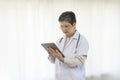 Confident senior female doctor using tablet computer standing in clinic. Royalty Free Stock Photo