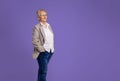 Confident senior female professional manager with hands in pockets looking away and contemplating while standing isolated over Royalty Free Stock Photo