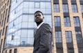 Confident serious african american businessman standing outside modern office building and looking away Royalty Free Stock Photo