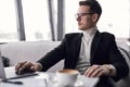 Confident serious executive in suit sit in restaurant working on laptop Royalty Free Stock Photo