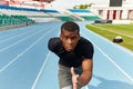 Confident serious motivated man running on a stadium track, fast speed motion Royalty Free Stock Photo