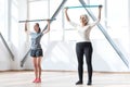 Confident serious women working out with a gymnastic stick