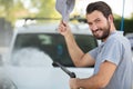 confident serviceman with high pressure water jet washing car Royalty Free Stock Photo
