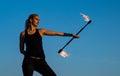 Confident sexy woman perform flaming baton twirling during dangerous fire show blue sky outdoors, brave