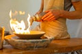 Confident skilled man setting clay plate on fire