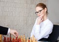 Confident smart businesswoman playing chess and smile