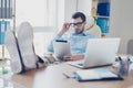 Confident smart intelligent elegant handsome serious strong-minded man with glasses is holding a digital table in hands and Royalty Free Stock Photo