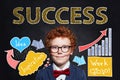 Confident smart kid businessman with Success inscription on chalkboard background. Success, career and develop concept