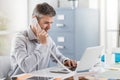 Confident smiling businessman and consultant working in his office, he is having a phone call: communication and business concept Royalty Free Stock Photo