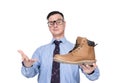 Confident smiling businessman in a shirt, tie and glasses demonstrates a shoe in his hand to a buyer, isolated on white background Royalty Free Stock Photo