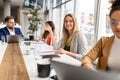 Confident smiling businesswoman with notepad on table collaborating with professional team in modern office Royalty Free Stock Photo