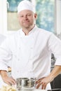 Confident and smiling chef standing in large kitchen Royalty Free Stock Photo