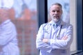 Confident smiling doctor posing and looking at camera with arms crossed Royalty Free Stock Photo