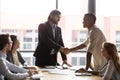 Confident smiling executive shaking African American employee hand at meeting Royalty Free Stock Photo