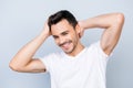 Confident smiling handsome young man in white t shirt. standing