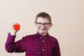 Confident smiling little boy nerd ,holding a puzzle cube .Concept happy,nerd.