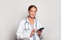 Confident smiling modern mid adult woman doctor medical worker practitioner using smart phone, female portrait Royalty Free Stock Photo