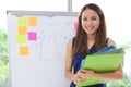 Confident smiling young Asian executive woman with document folder standing in office. Thoughtful and leadership business concept Royalty Free Stock Photo