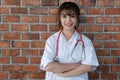 Confident smiling young female doctor posing with arms crossed. Royalty Free Stock Photo