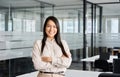 Confident smiling young Asian business woman standing in office, portrait. Royalty Free Stock Photo