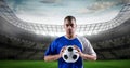 Confident soccer player holding ball at stadium