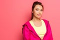 , confident sportswoman in pink windbreaker smiling