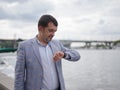 Successful businessman looking at the watch on his hand on the urban background. Wealth concept. Copy space. Royalty Free Stock Photo