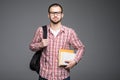 Confident student. Studio portrait of handsome young man holding books isolated on gray Royalty Free Stock Photo