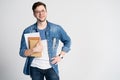 Confident student. Studio portrait of handsome young man holding books. Isolated on white. Royalty Free Stock Photo