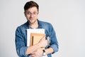 Confident student. Studio portrait of handsome young man holding books. Isolated on white. Royalty Free Stock Photo