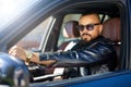 Confident stylish bearded man in sunglasses driving a car Royalty Free Stock Photo