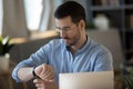 Confident businessman checking time, looking at wrist watch