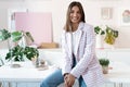 Confident young woman in smart casual wear smiling while standing near her working place Royalty Free Stock Photo