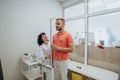 Female doctor measuring young patient height using metric scale at the hospital.