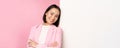 Confident, successful japanese office lady in suit, cross arms, looking as professional at camera, leaning on white wall Royalty Free Stock Photo