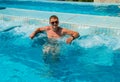 Confident Successful man relaxing in pool jacuzzi outdoor at spa resort enjoying luxury life. Success, healthy lifestyle, body car