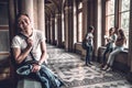 Confident and successful student.Handsome male student sitting on the railing and looking at camera