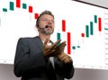 Confident successful trader man with headset speaking at event coaching trading business at auditorium or conference room teaching