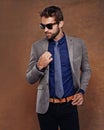 Confident, sunglass fashion and male model in studio for corporate trends on brown background for businessman aesthetic Royalty Free Stock Photo