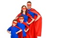 confident super family in masks and cloaks standing with hands on waist and smiling at camera Royalty Free Stock Photo