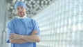 A confident surgeon wearing blue medical suit in the hospital hall