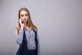 Confident talk. Beautiful young business woman talking on the mobile phone while standing against grey background Royalty Free Stock Photo