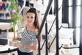 Confident team leader. Confident young woman holding a cup of hot coffee in her hands and looking at camera with smile Royalty Free Stock Photo